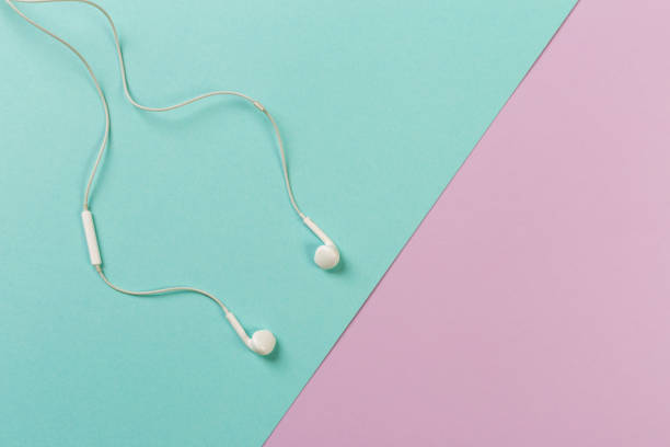 istock White earphones on colour background 1083730136
