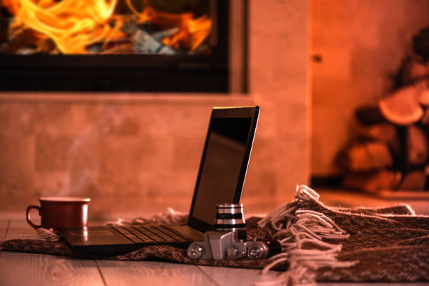 istock Laptop or notebook, camera, cup on the fireplace background. 1083736524