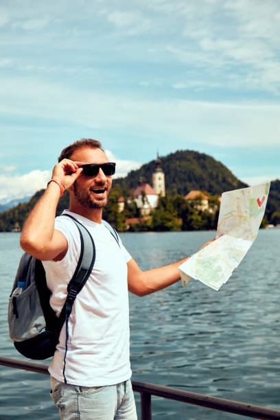 istock Tourist man holding map and enjoying on the lake. 1083741012