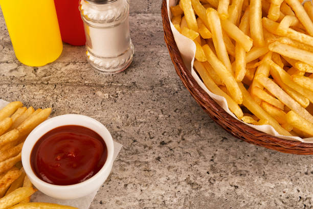 istock French fries basket with ketchup on concrete background. 1083743380