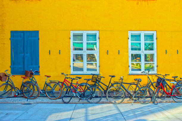 велосипеды у стены в копенгагене, дания. - shutter wood window europe стоковые фото и изображения
