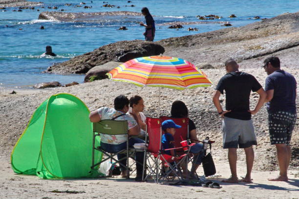 bunten sonnenschirm am strand - cape town beach crowd people stock-fotos und bilder