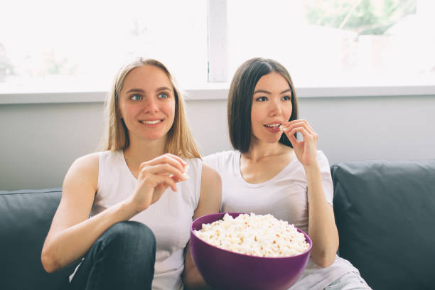 istock Women eating popcorn and watching tv 1083755280