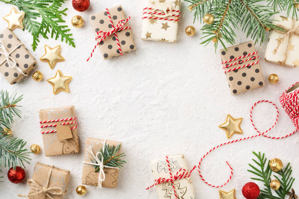 istock Decorated Christmas gift boxes, gold ornaments, twine & spruce frame on white background. 1083760506