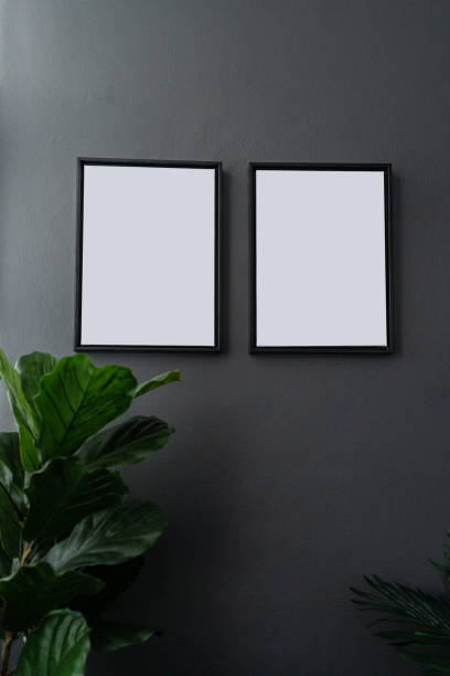 istock Compostion empty natural wooden frames setting on gray painted wall surrounded by artificial plants setting in natural lighting scene / cozy interior concept / object isolated 1083760658