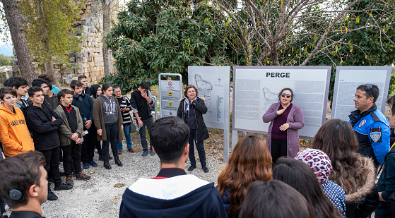 Antalya, Turkey - December 11, 2018 : Tour guides are being trained to be ready for different kind of groups. In this photo, guide is giving the tour of Perge Antique City in sign language for hearing-impaired tourists.