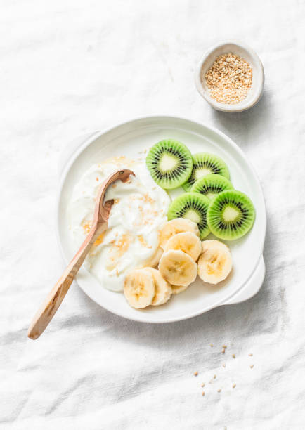 istock Healthy diet breakfast - greek yogurt with honey and fruit on a light background, top view. Copy space 1083763110