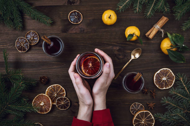 istock Flatlay of woman's hands holding cup with mulled wine on wooden table 1083769852