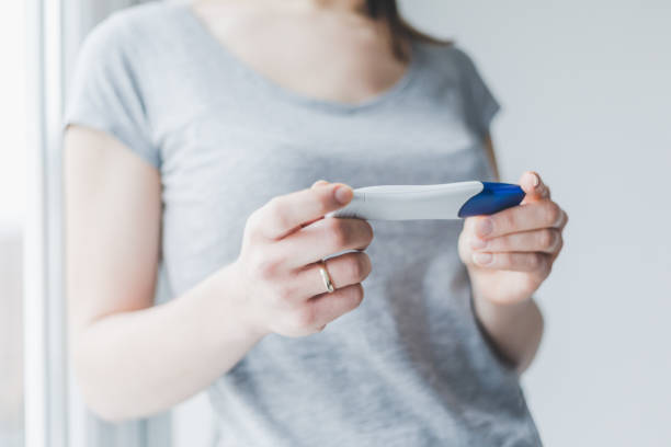 istock Woman looking and checking pregnancy test 1083774740