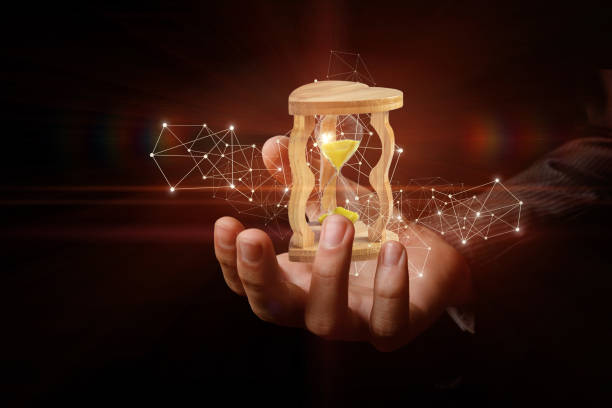 istock A sand watch is standing inside a businessman's hand surrounded by wireless digital connections. 1083788226