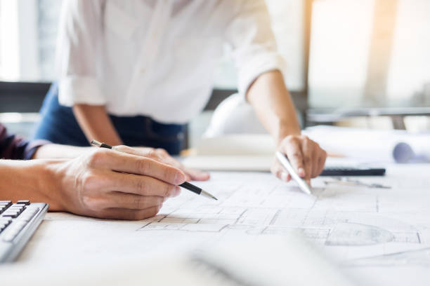 istock Midsection Of Architects Discussing Over Blueprint At Office 1083789370