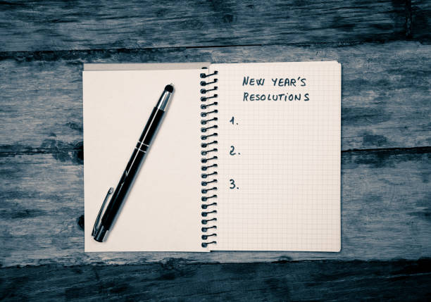 istock Top View 2019 New year resolutions blank list to write wishes for new life on notepad on Vintage table in Wish list and Goals for happiness Aspiration and Motivation Concept in Black and white image. 1083789590