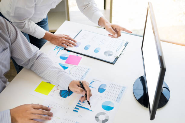 istock Midsection Of Business People Working Over Graphs With Laptop On Table 1083789926