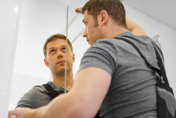 istock Handyman installing glass cabinet in bathroom. 1083792544
