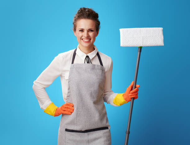istock happy young cleaning lady in apron with mop on blue 1083794990