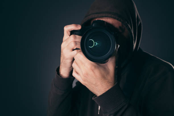 istock Hooded photographer behind DSLR camera 1083795944