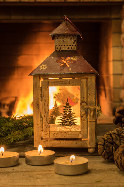 istock christmas lantern ,candles and cones , on old brown table, before cozy fireplace. 1083796182