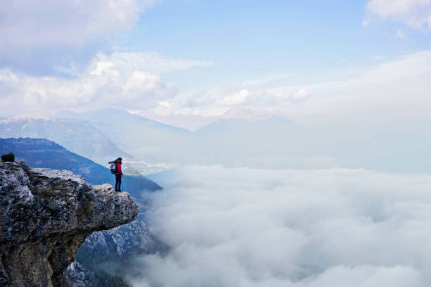 istock Hiker man in red jacket enjoys view over clouds. 1083798572