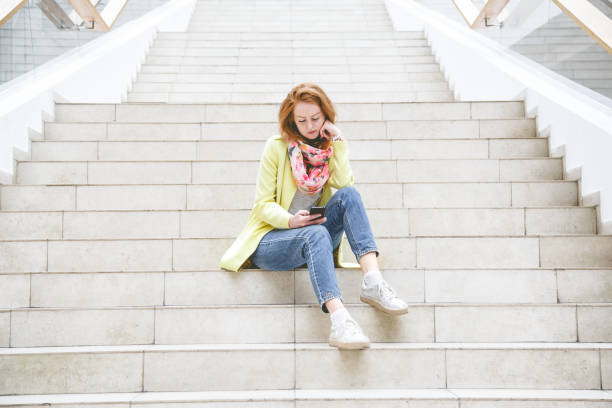 istock Woman on the stairs using smartphone 1083799290