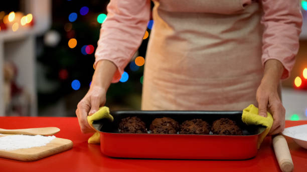 istock Lady putting cooking dish with biscuits on table, traditional Xmas celebration 1083799362
