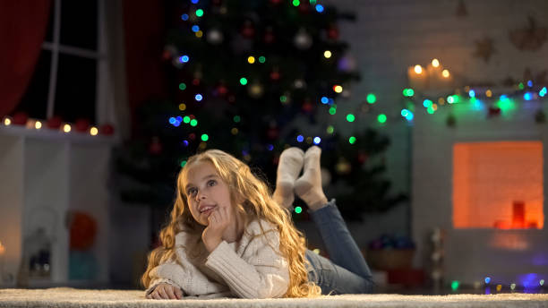 istock Blond girl lying on floor thinking about X-mas celebration, waiting for presents 1083802694