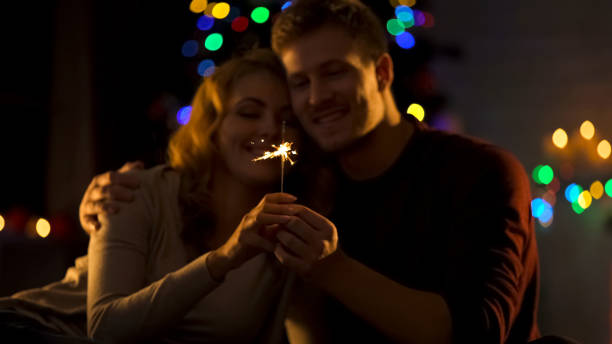 istock Romantic couple looking at Bengal light, making wish on Christmas, miracle 1083803008