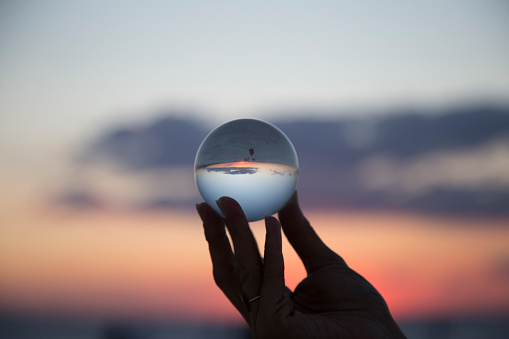woman's hand with crystal ball Sunset