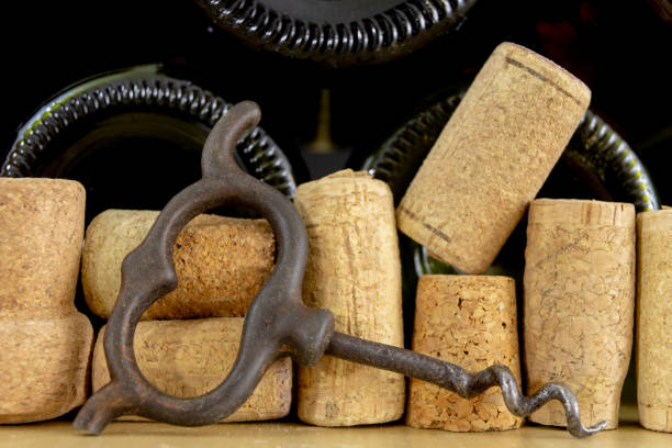 istock A corkscrew for uncorking wine and old corks on a wooden table. Old wine accessories. Light background. 1083806664