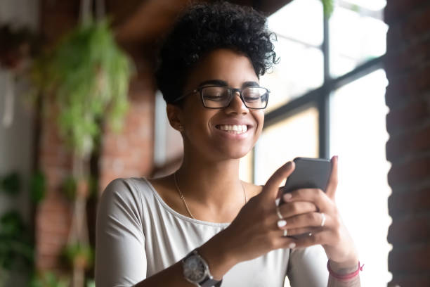 istock Smiling African American woman using phone, get good message 1083813224