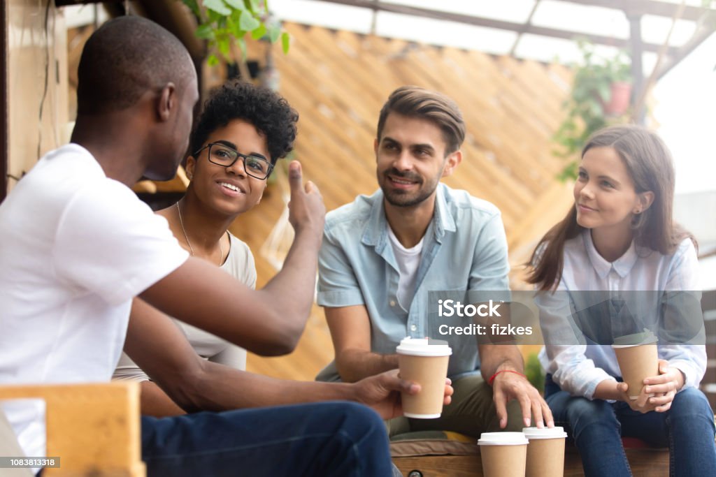 Afrikanische amerikanische Mann zeigt Daumen bis zu Freunden im café - Lizenzfrei Reden Stock-Foto