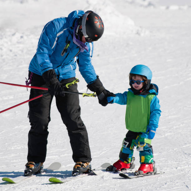 istock Father And Son Skiing On Snow Covered Field During Winter 1083820494