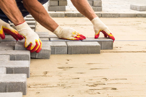 workers lay paving tiles, construction of brick pavement, close up architecture background stock photo
