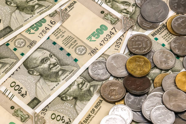 istock Indian rupees coins. 500 rupee banknotes in background. 1083826126