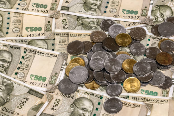 istock Indian rupees coins. 500 rupee banknotes in background. 1083826182