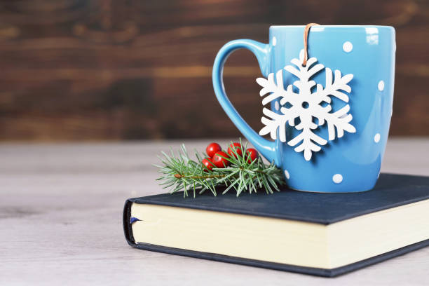 istock Christmas tea and book on wooden background 1083826426