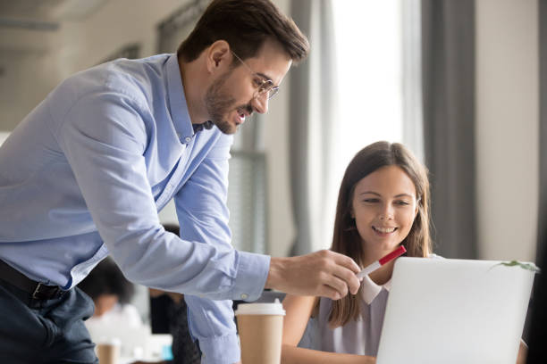 istock Mentor explaining task to smiling female employee 1083827584