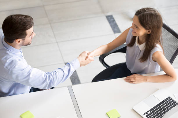 istock Friendly smiling employee shaking hand with young woman 1083827598