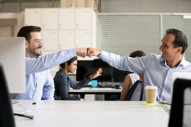 istock Friendly smiling male colleagues fist bumping at workplace 1083827640