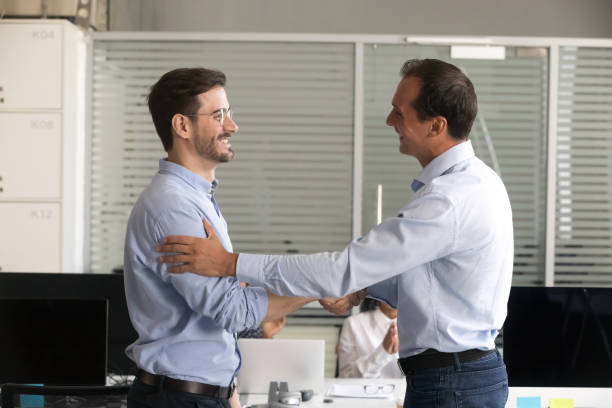 istock Friendly middle aged boss handshaking male employee 1083827670