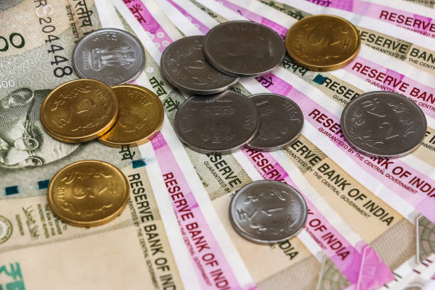 istock Indian rupees coins. 500 and 2000 rupee banknotes in background. 1083827684