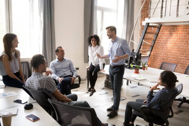 istock Confident male leader, coach talking with group of office workers 1083827800