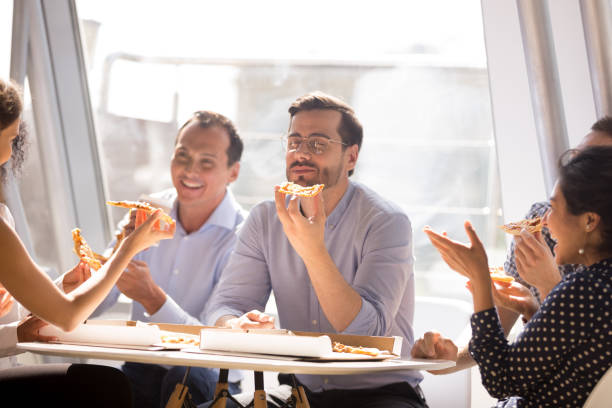 istock Businessman enjoying pizza with friendly colleagues during break 1083827826