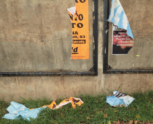 torn billboards Calci, Italy - November 25, 2018: old torn billboards have fallen on the ground just under the space that was allocated for them along a public street of this small town at the foothills of Mt Serra, in Tuscany wild posting ad stock pictures, royalty-free photos & images