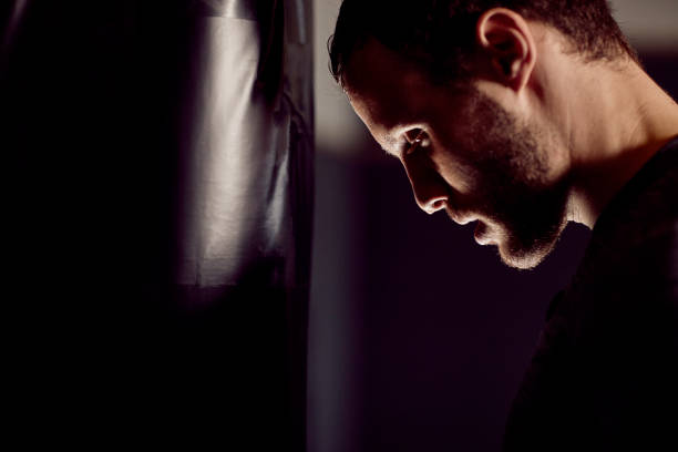 istock fit boxer training and hitting a punching bag 1083830726