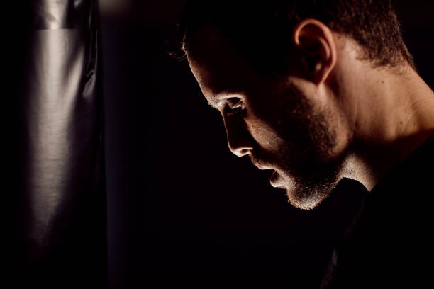 istock fit boxer training and hitting a punching bag 1083832404