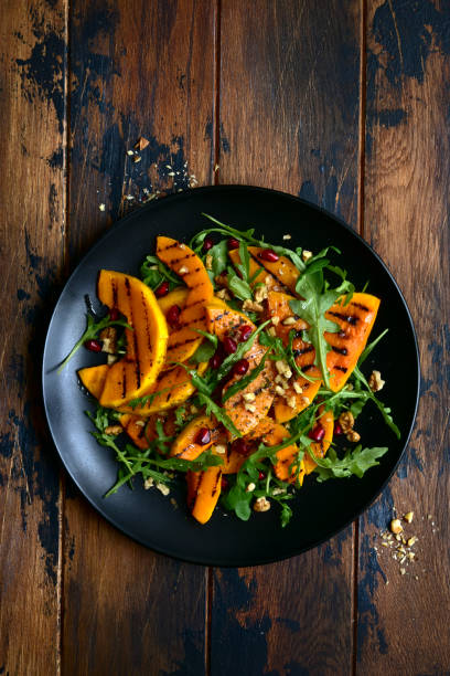istock Grilled pumpking warm salad with arugula, walnuts and pomegranate seeds 1083844344