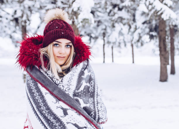 istock Female covered in warm blanket in the forest on snowy day. 1083853632