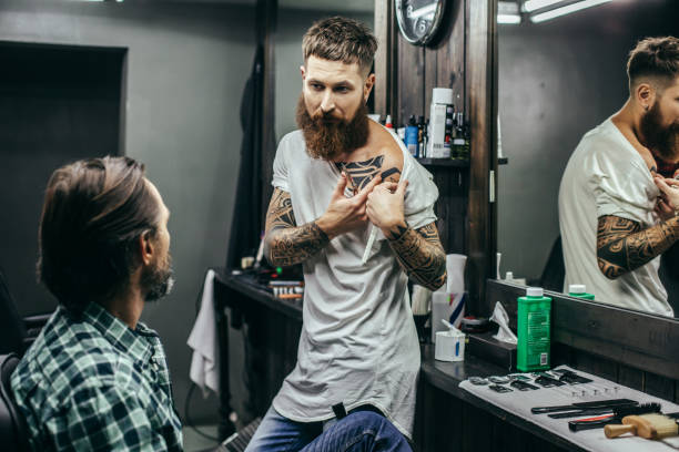 istock Calm bearded barber looking at his visitors and showing his tattoos 1083853762
