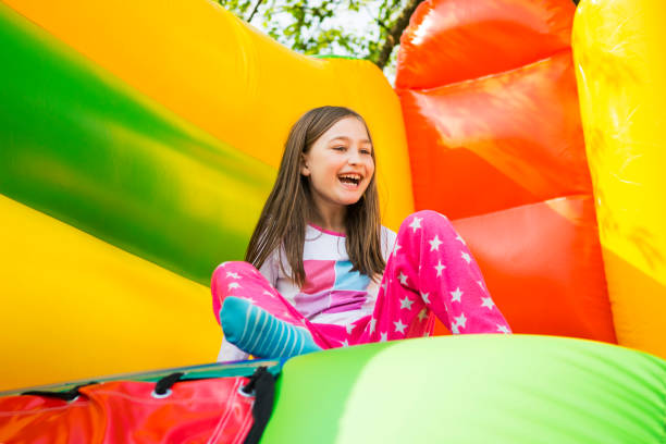 chica feliz en el castillo de juego - inflatable child playground leisure games fotografías e imágenes de stock
