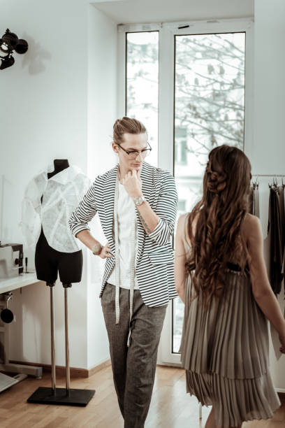 istock Long-haired fashion designer in eyeglasses looking thoughtful 1083856028